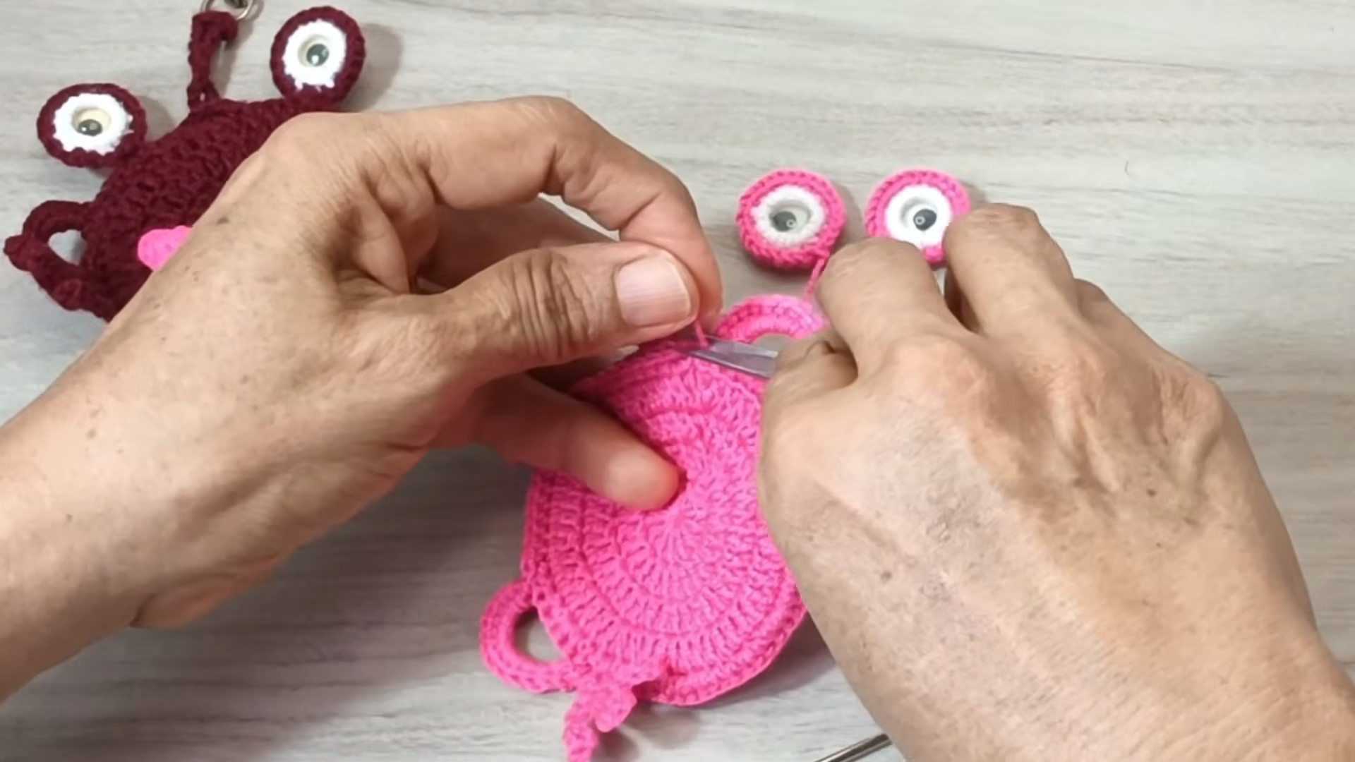 Sewing the eyes and side loops onto the body.