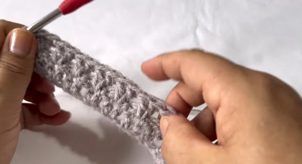 Showing the long gray strip with its textured stitch pattern.