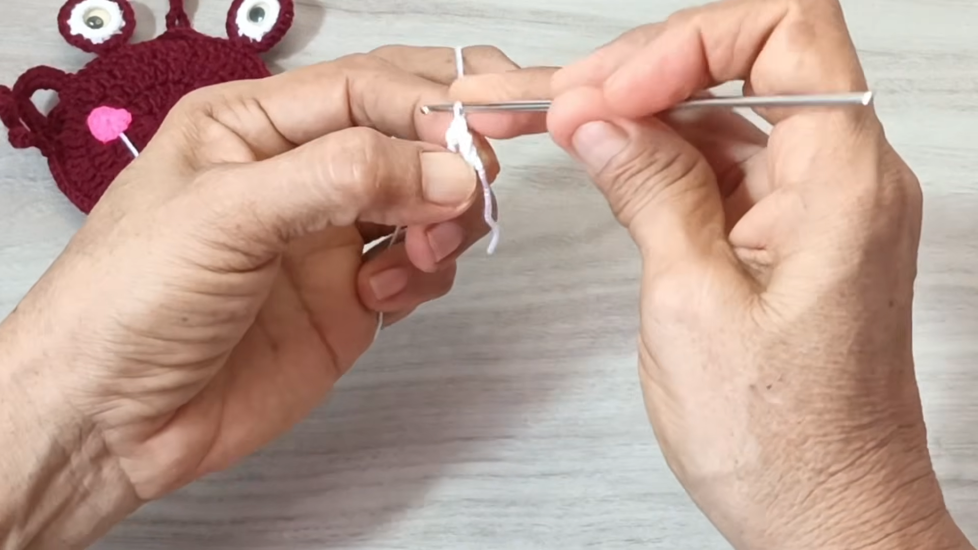 Starting a magic ring with white yarn.