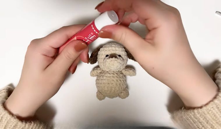Crochet dog keychain pattern puppy with glue fixing the ears and arms